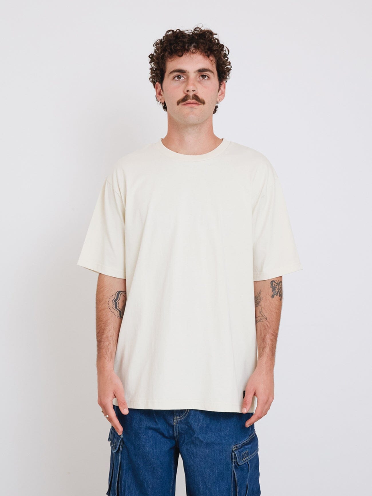 Male model wearing our Thrills Thrills Military Oversize Fit Tee in White standing against a plain studio background.