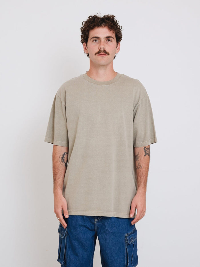 Male model wearing our Thrills Thrills Military Oversize Fit Tee in Grey standing against a plain studio background.