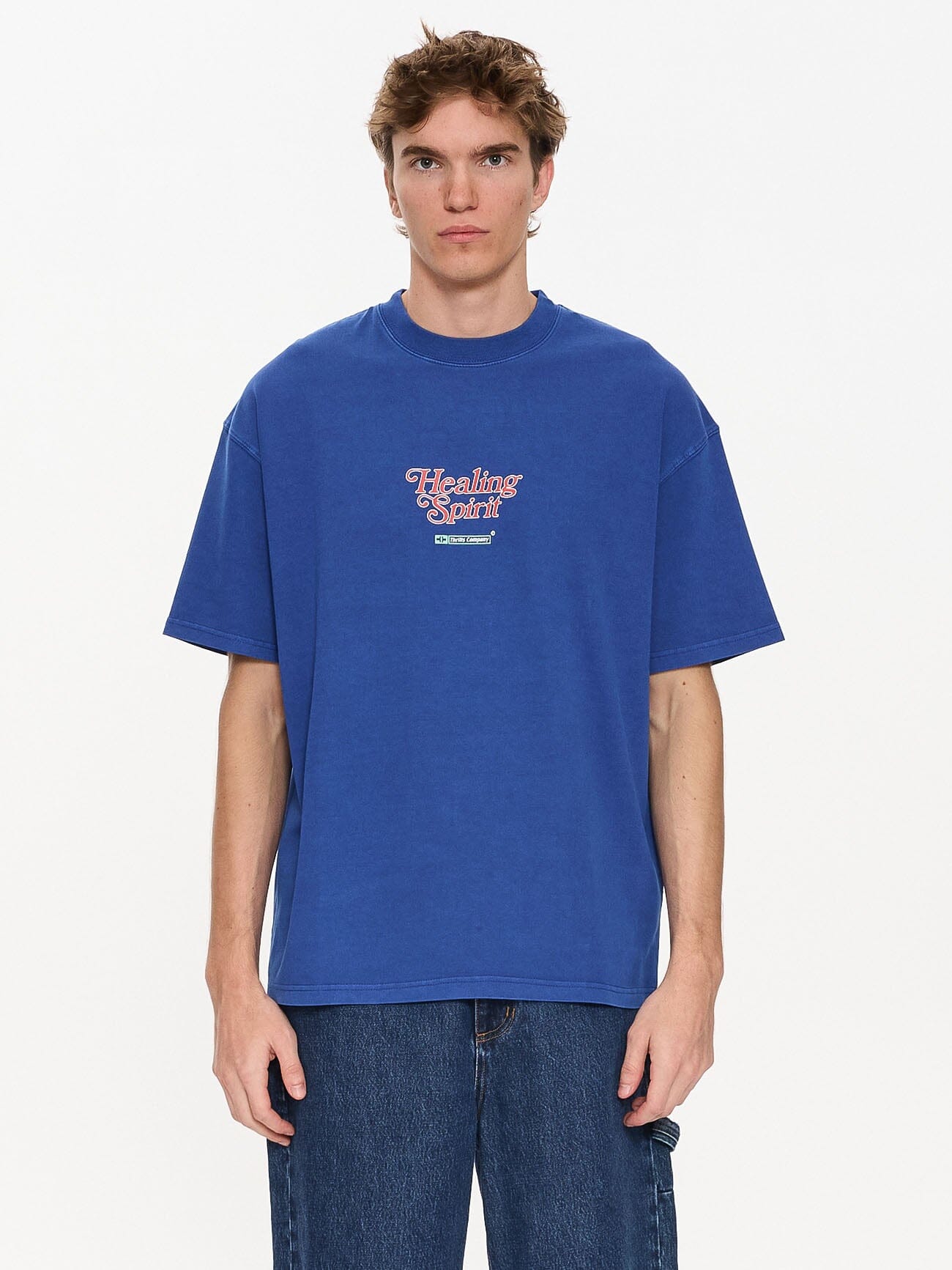 Male model wearing our Thrills Prediction Box Fit Oversize Tee in Blue standing against a plain studio background.