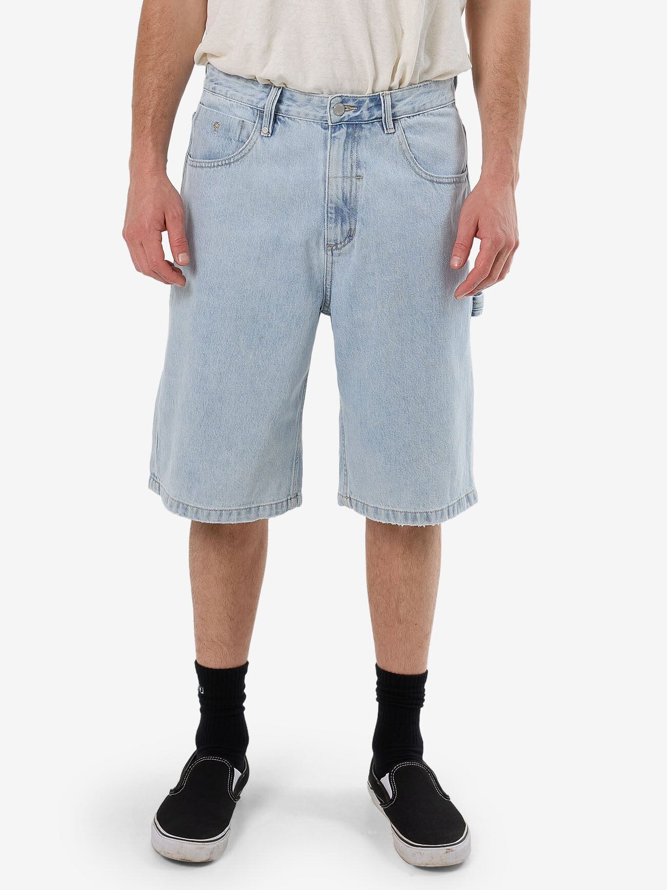 Male model wearing our Thrills Big Slacker Denim Short in Blue standing against a plain studio background.