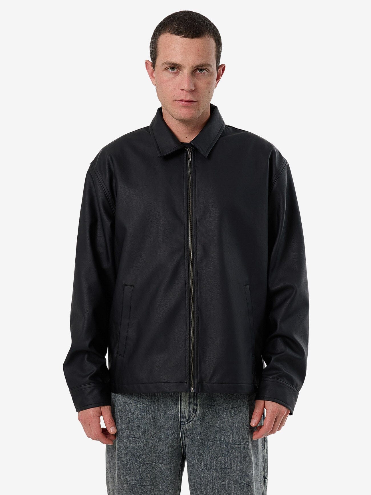 Male model wearing our Thrills Don't Bother Me Work Jacket in Black standing against a plain studio background.
