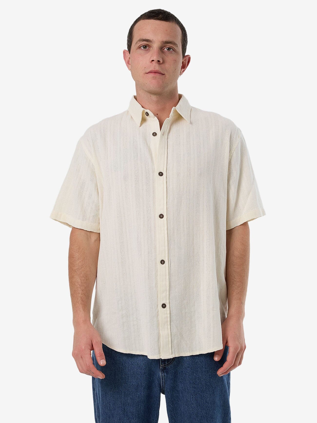 Male model wearing our Thrills Unhinged 2.0 Short Sleeve Shirt in White standing against a plain studio background.