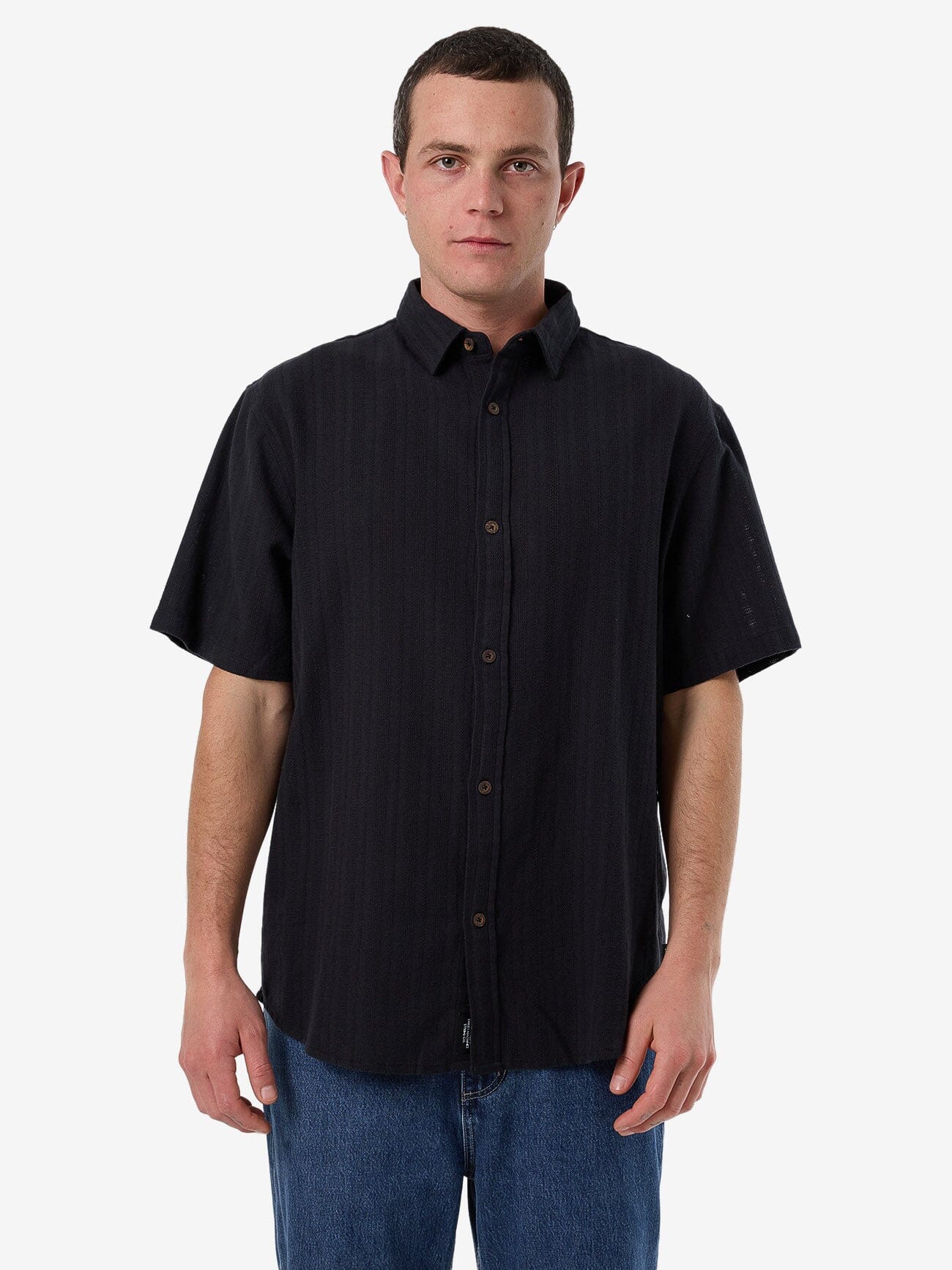 Male model wearing our Thrills Unhinged 2.0 Short Sleeve Shirt in Black standing against a plain studio background.