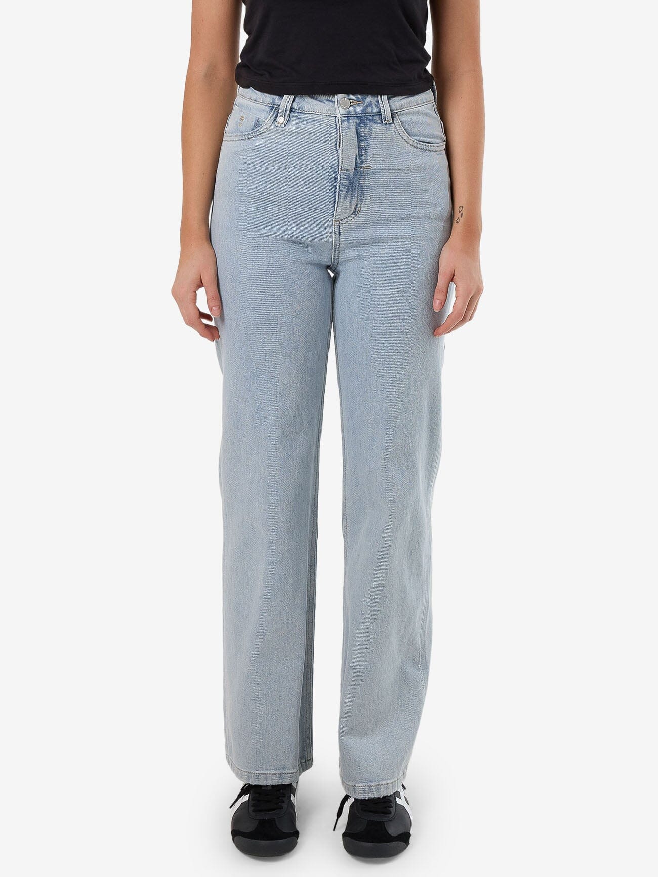 Female model wearing our Thrills Cherry Stretch Jean in Blue standing against a plain studio background.