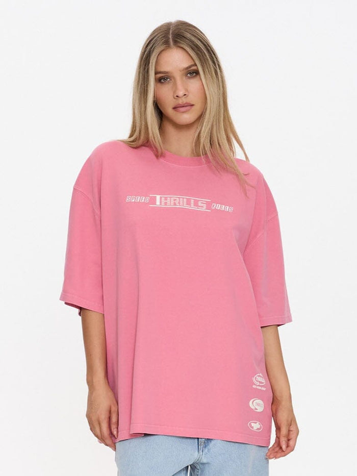 Woman wearing a pink oversized t-shirt and light blue jeans on a white background