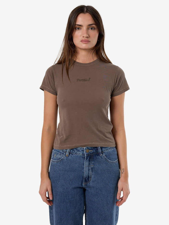 Female model wearing our Thrills Thrills Workwear Boy Tee in Brown standing against a plain studio background.