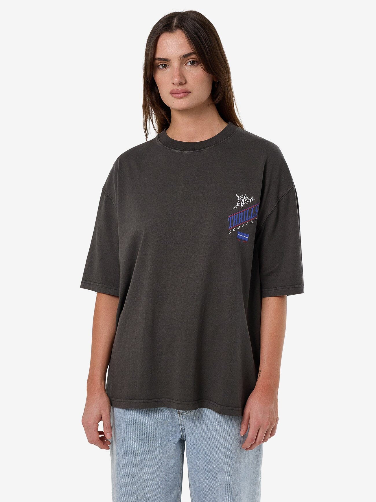 Female model wearing our Thrills When It Hits Your Lips Oversized Tee in Black standing against a plain studio background.