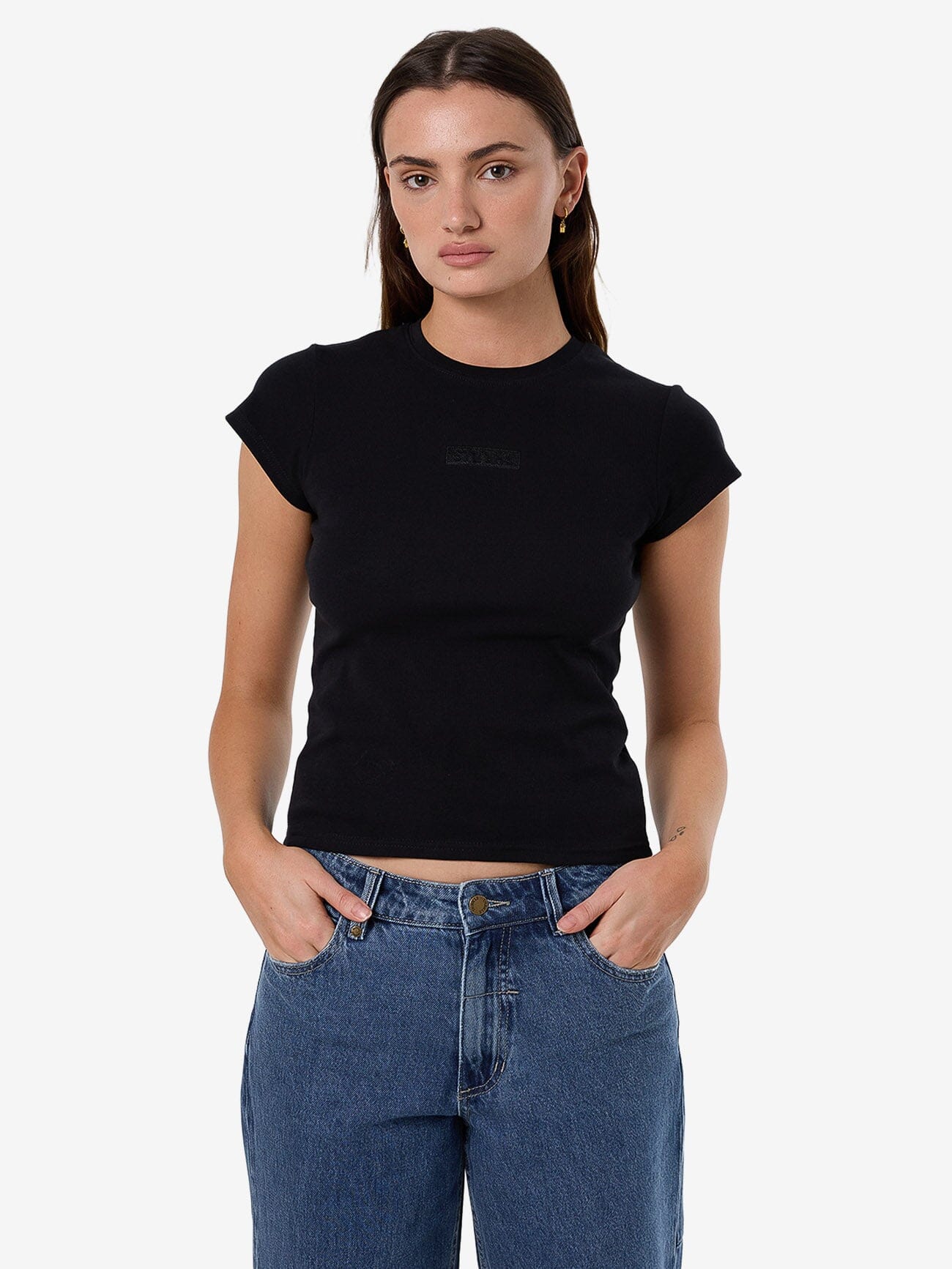 Female model wearing our Thrills Superior Club Tee in Black standing against a plain studio background.