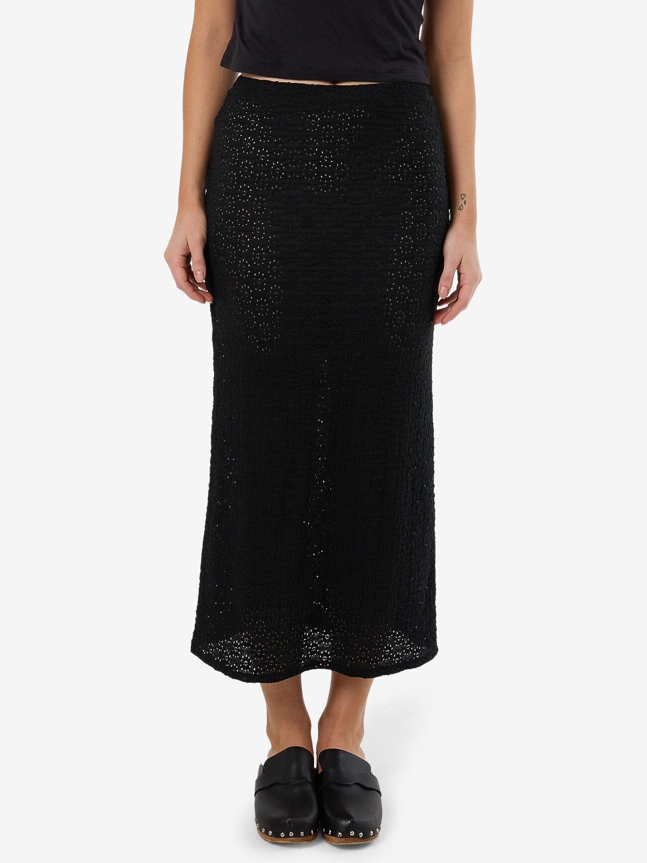 Female model wearing our Thrills Dollie Lace Skirt in Black standing against a plain studio background.