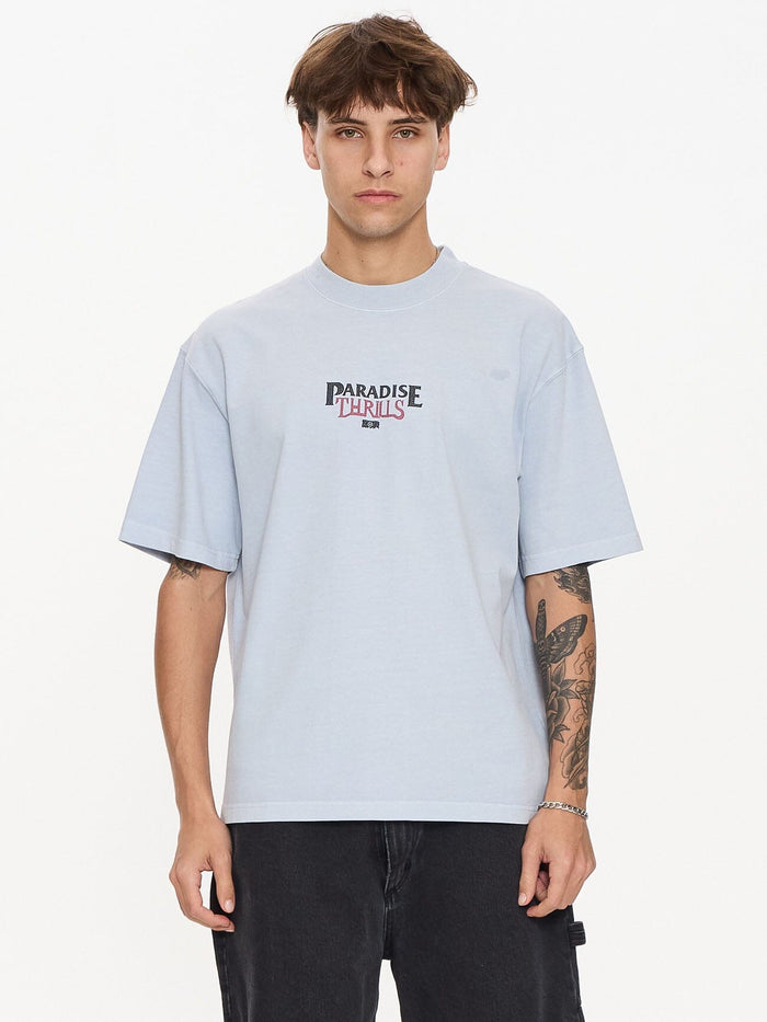 Male model wearing our Thrills Paradise Valley Box Fit Oversize Short Tee in Blue standing against a plain studio background.