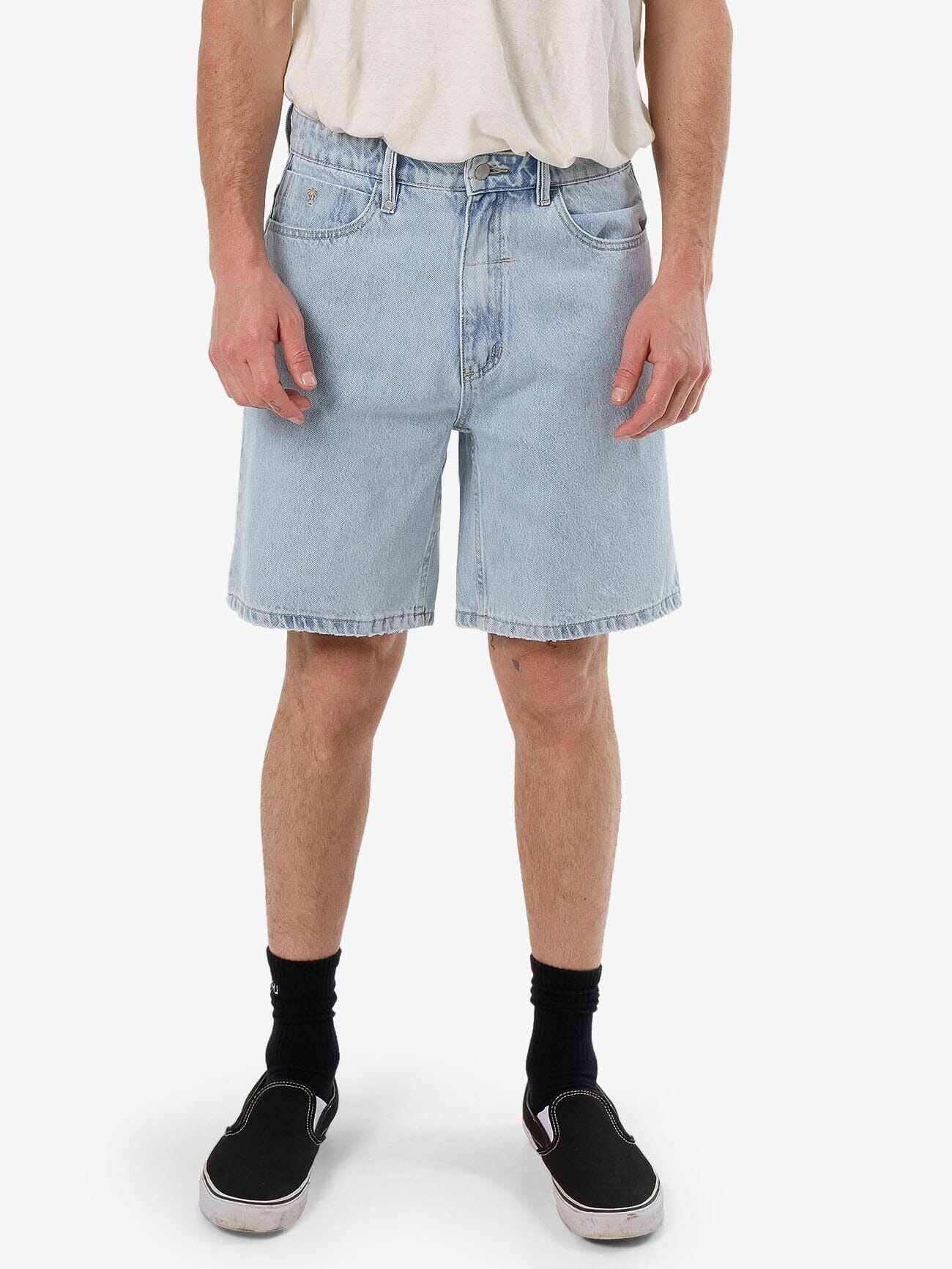 Male model wearing our Thrills Slacker Denim Short in Blue standing against a plain studio background.