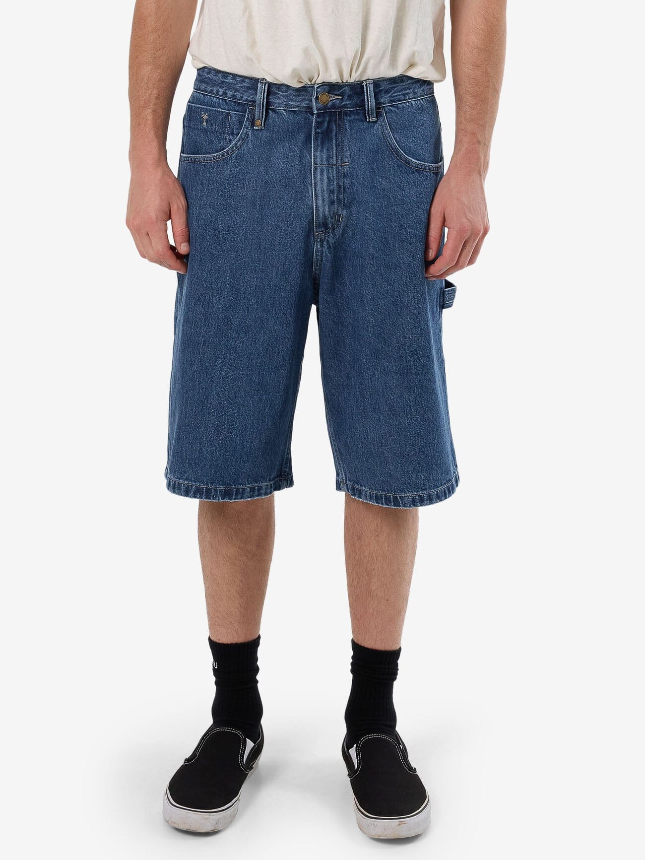 Male model wearing our Thrills Big Slacker Denim Short in Blue standing against a plain studio background.