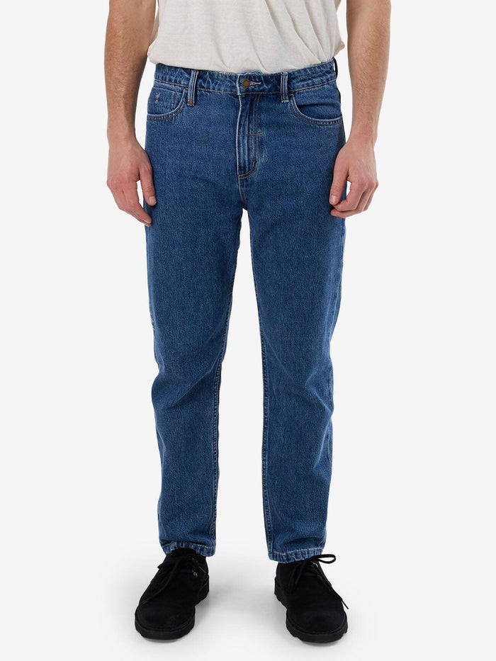 Male model wearing our Thrills Unchopped Denim Jean in Blue standing against a plain studio background.
