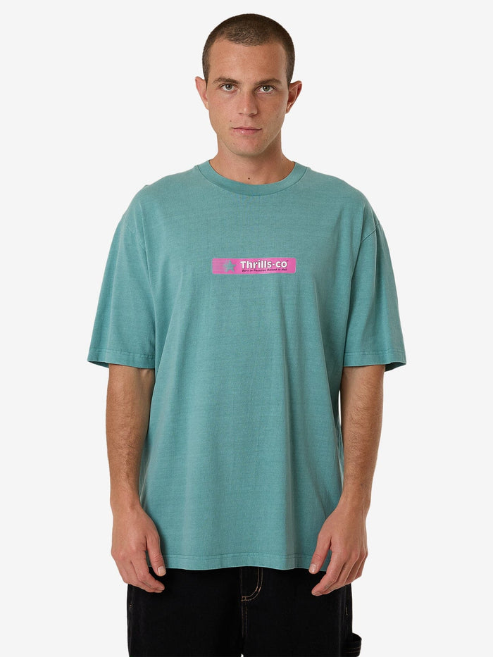 Male model wearing our Thrills Games Of 84' Oversize Fit Tee in Green standing against a plain studio background.