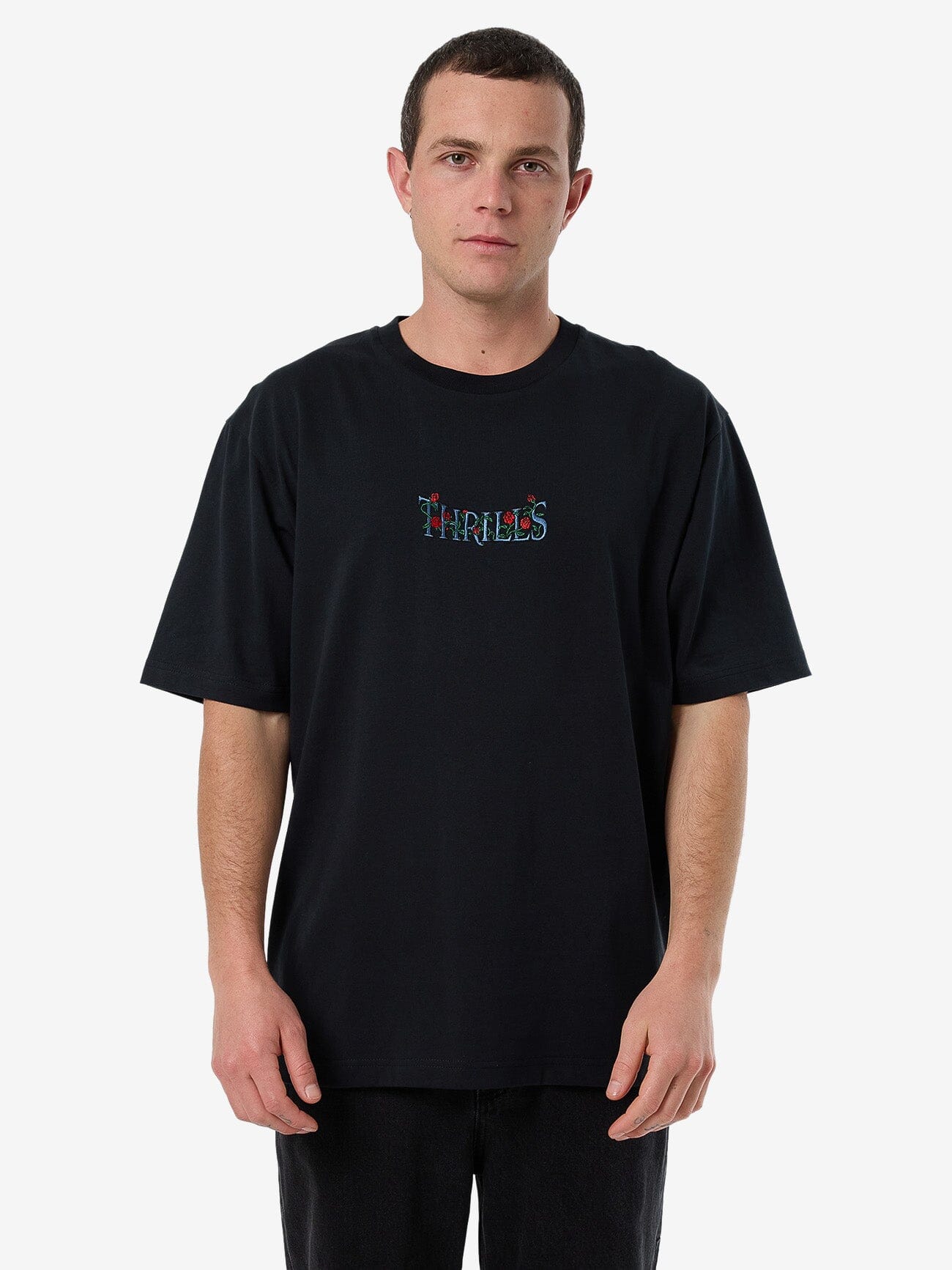 Male model wearing our Thrills Thorned Oversize Fit Tee in Black standing against a plain studio background.