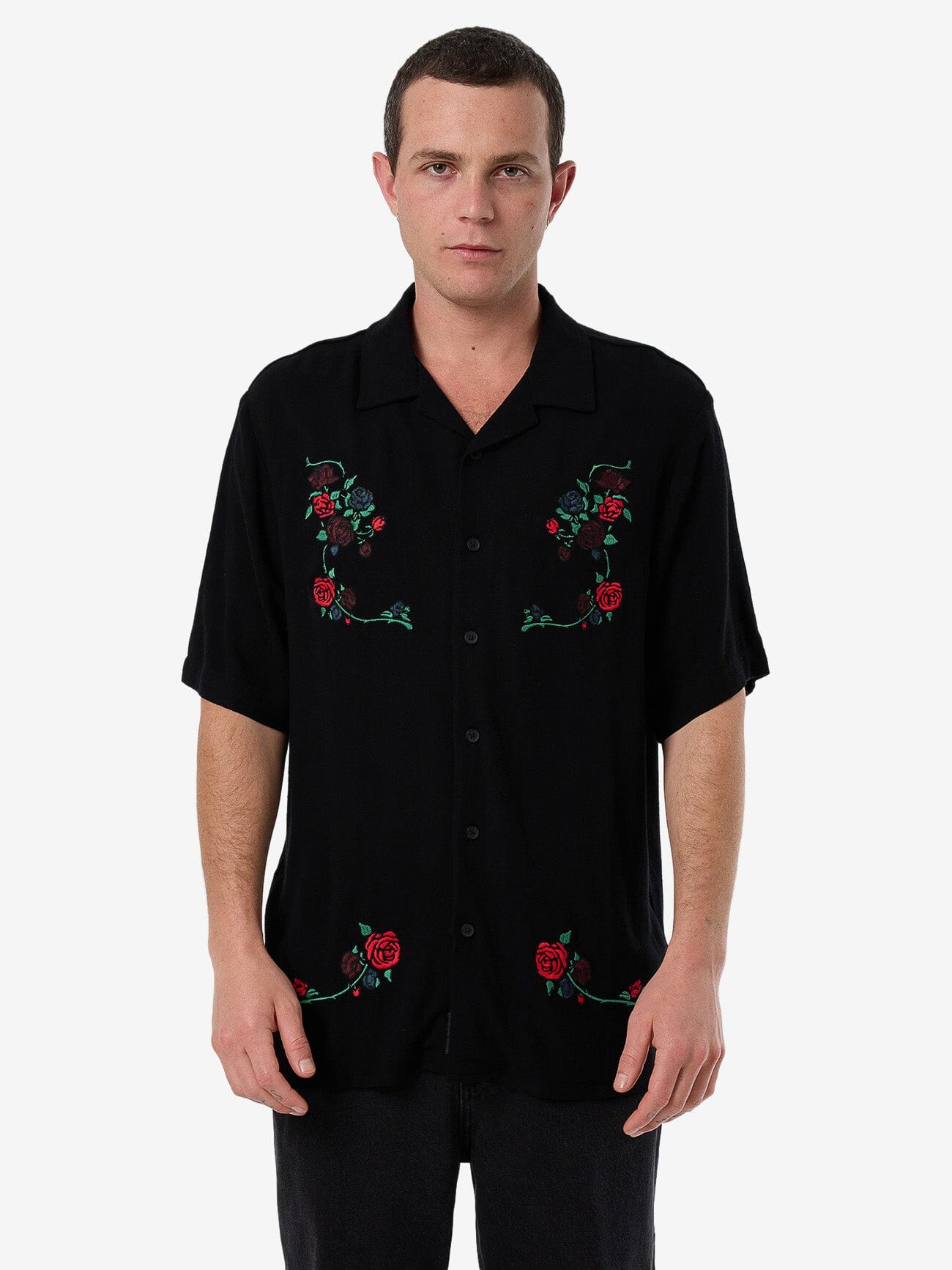 Male model wearing our Thrills Thorned Bowling Shirt in Black standing against a plain studio background.