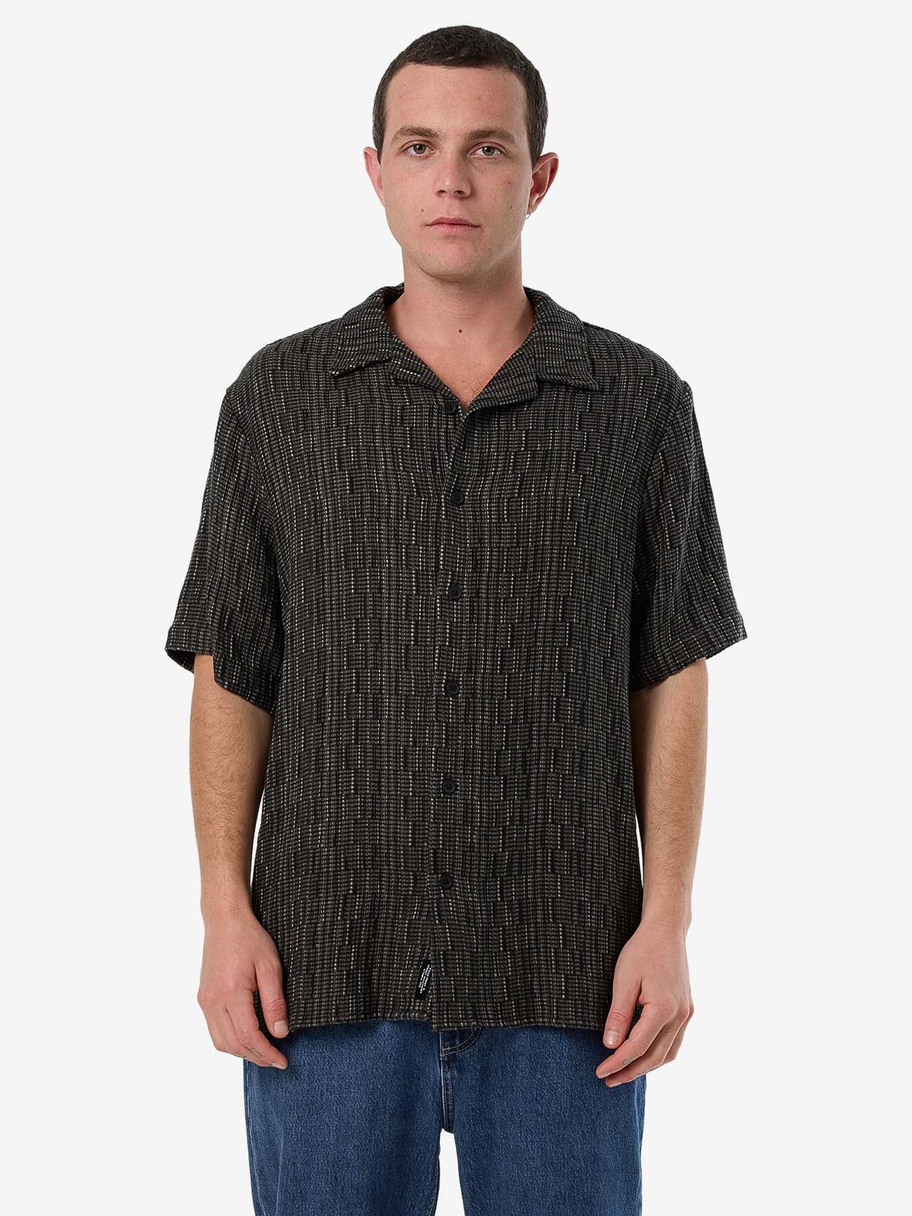 Male model wearing our Thrills Fortune Favors Bowling Shirt in Green standing against a plain studio background.