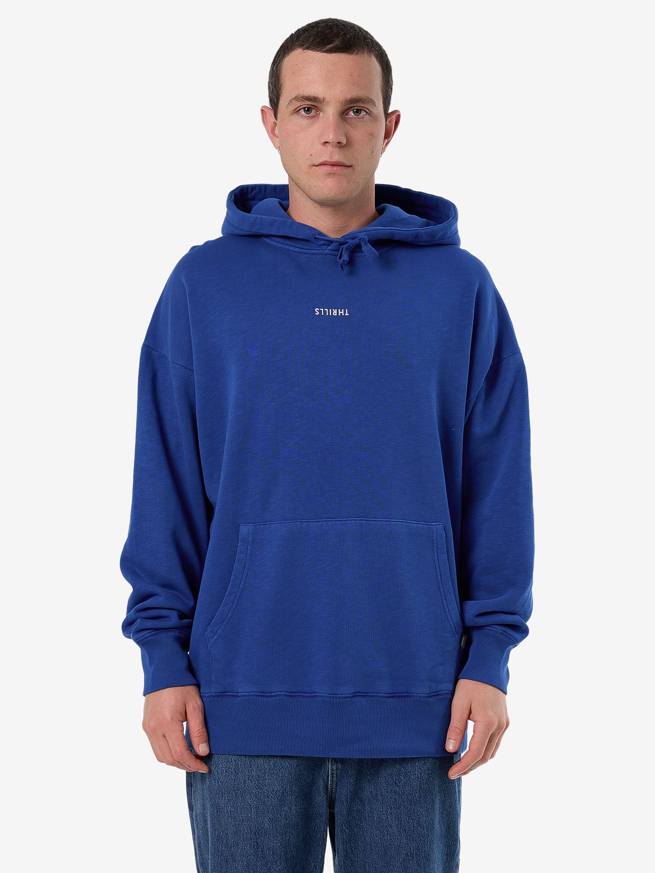 Male model wearing our Thrills Minimal Thrills Slouch Pull On Hood in Blue standing against a plain studio background.