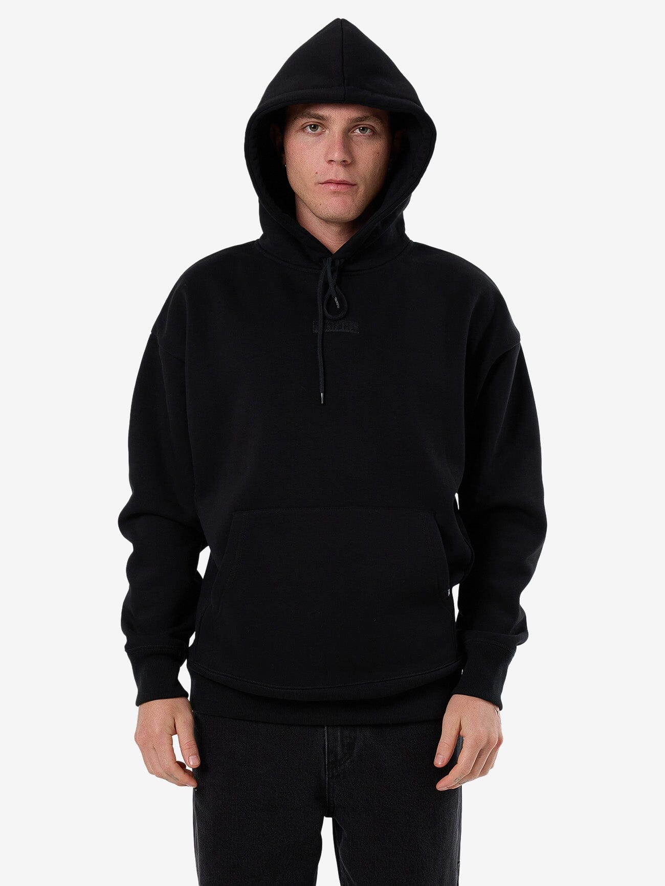 Male model wearing our Thrills Superior Thrills Slouch Pull On Short Hood in Black standing against a plain studio background.