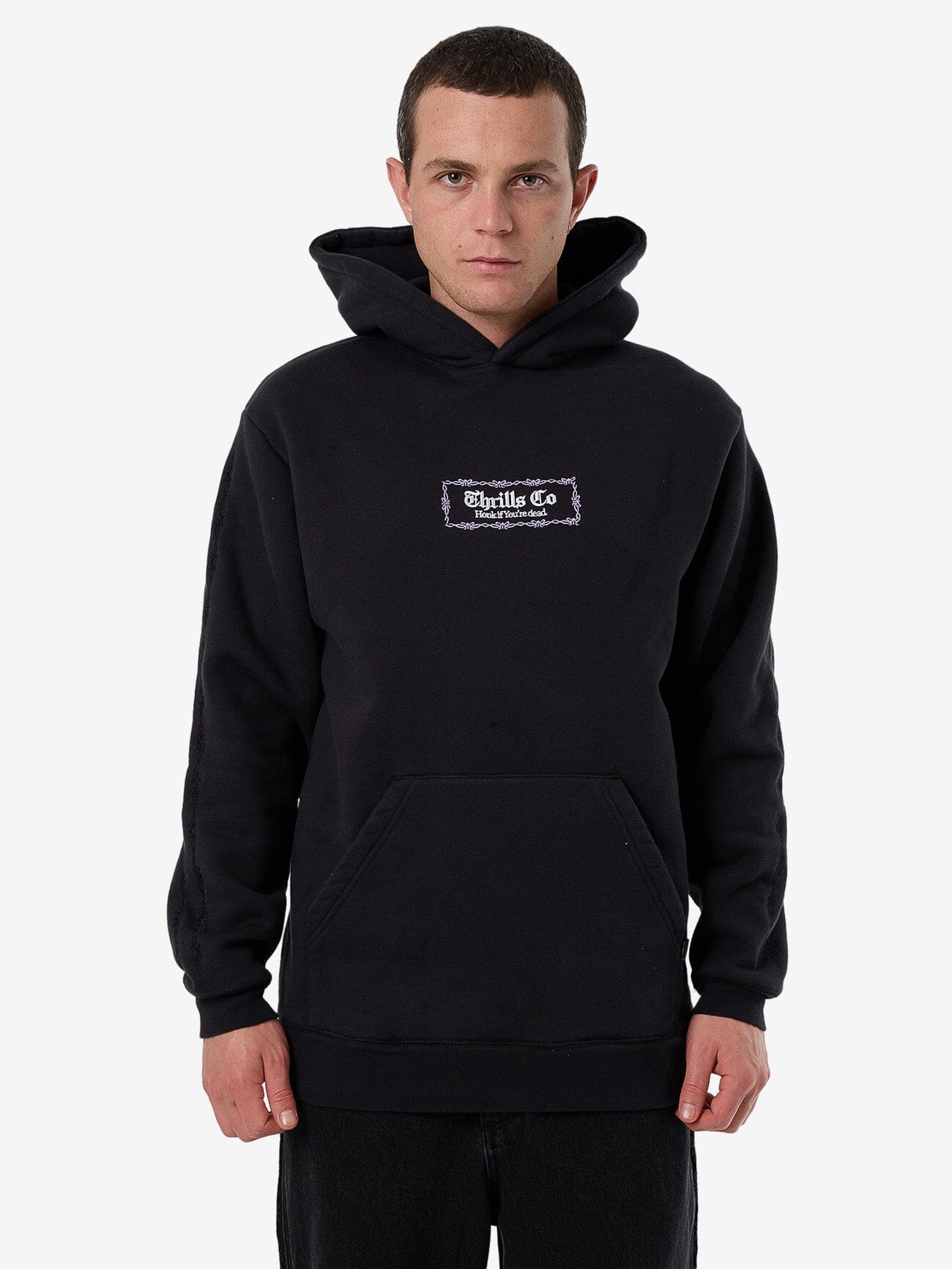 Male model wearing our Thrills Lighten Up Slouch Pull On Short Hood in Black standing against a plain studio background.