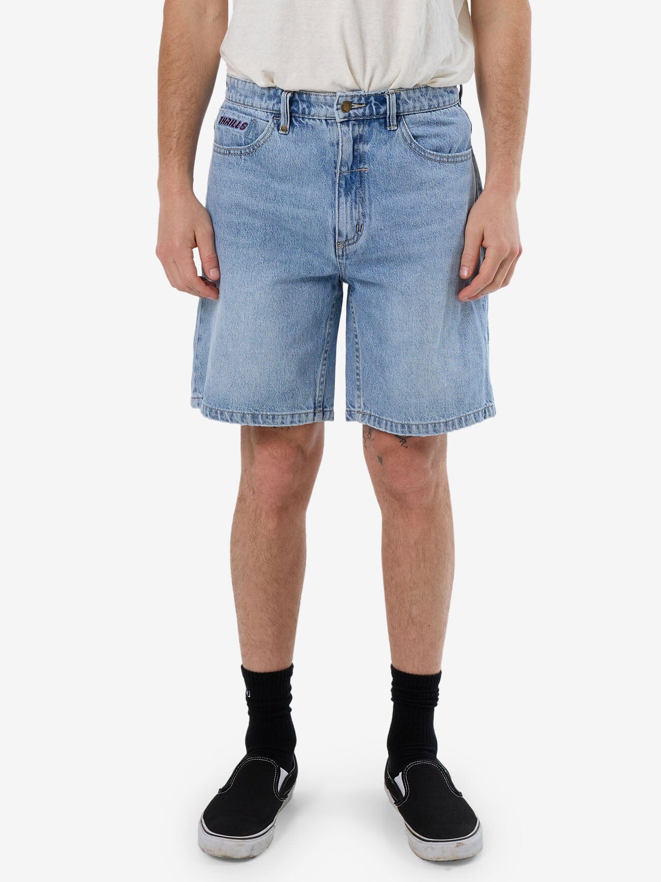 Male model wearing our Thrills Starpower Slacker Denim Short in Blue standing against a plain studio background.