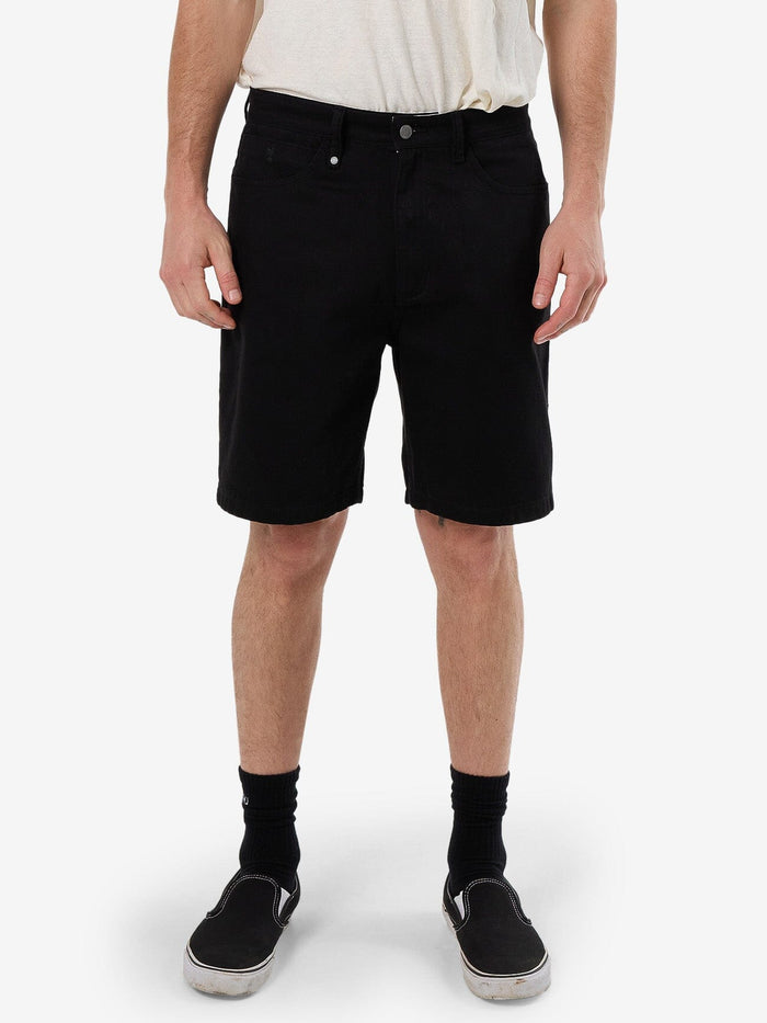 Male model wearing our Thrills Slacker Short in Black standing against a plain studio background.