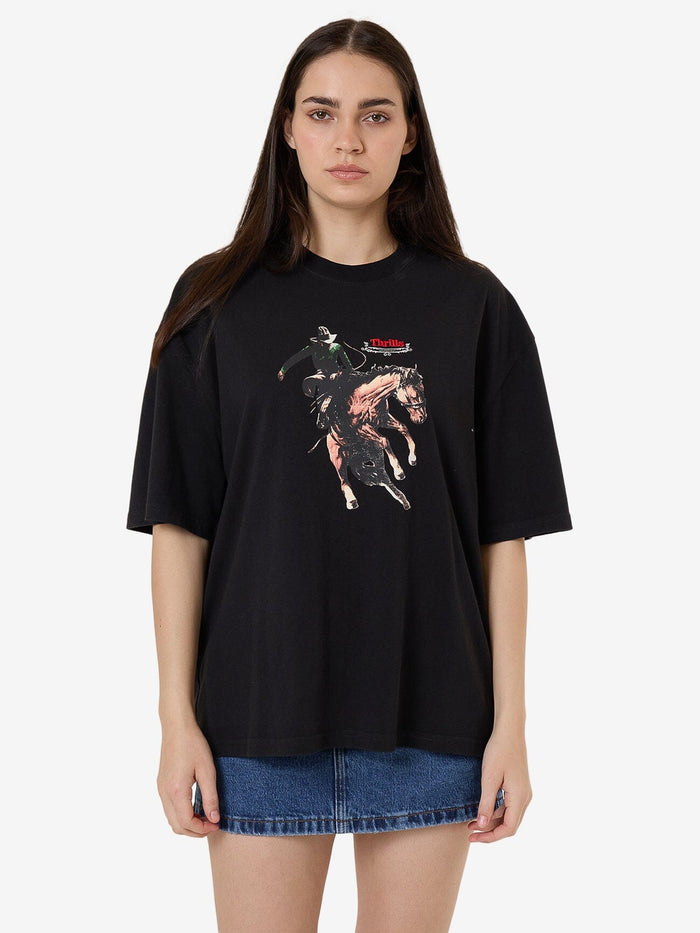 Female model wearing our Thrills Eternal Outlaw Oversize Tee in Black standing against a plain studio background.