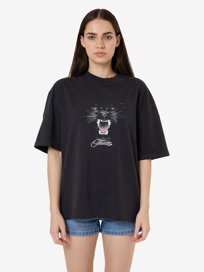 Female model wearing our Thrills Deadly Pursuit Oversized Tee in Black standing against a plain studio background.