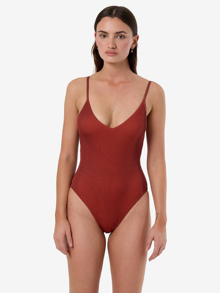 Female model wearing our Thrills Alba Rib Plunge One Piece in Orange standing against a plain studio background.